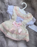 Luxe cream pinafore dress with frilly blouse and bows